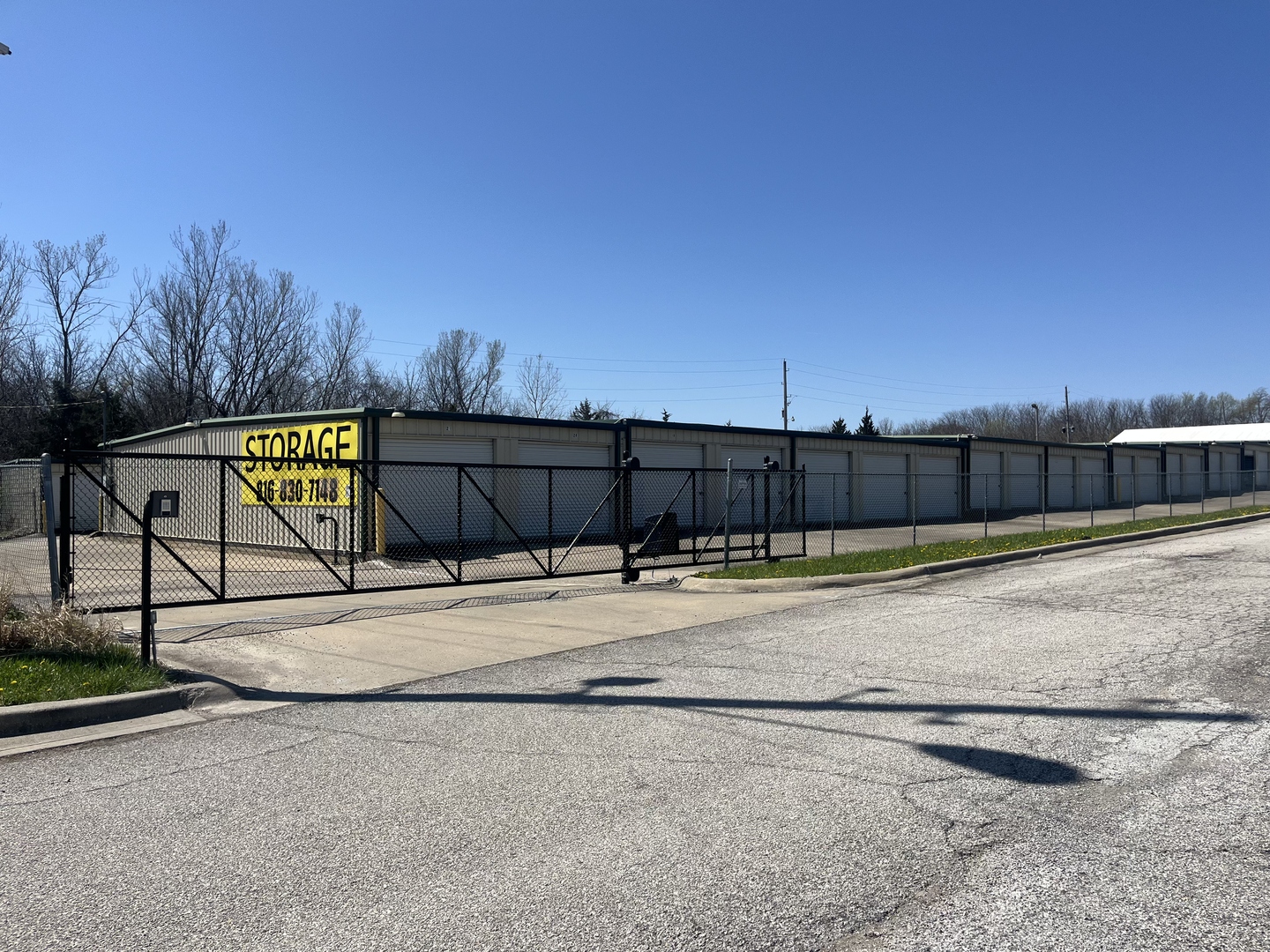 Peculiar Storage entrance with yellow Storage sign and (816) 830-7148 phone number