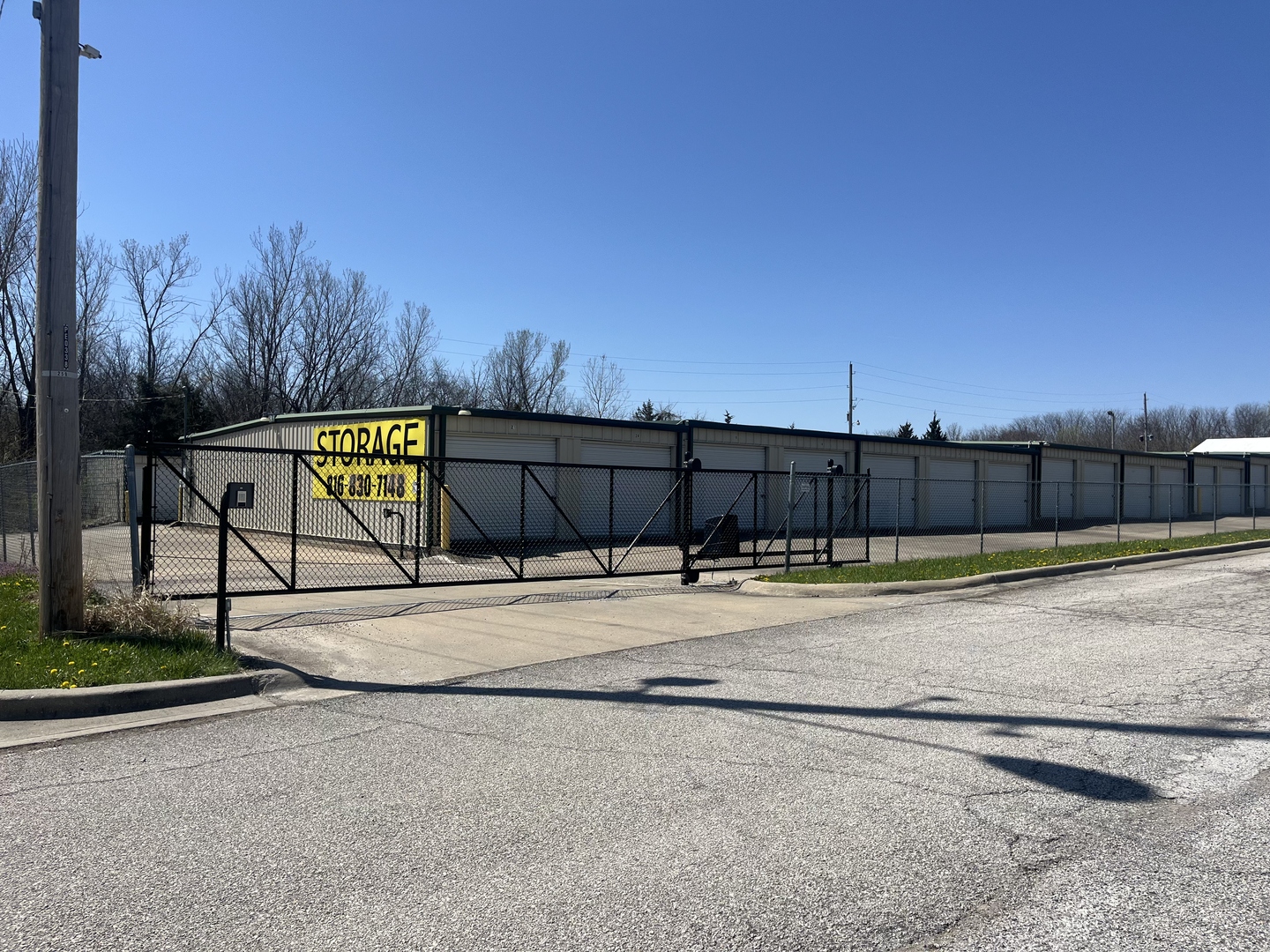 Gated entrance with security fence at Peculiar Storage facility